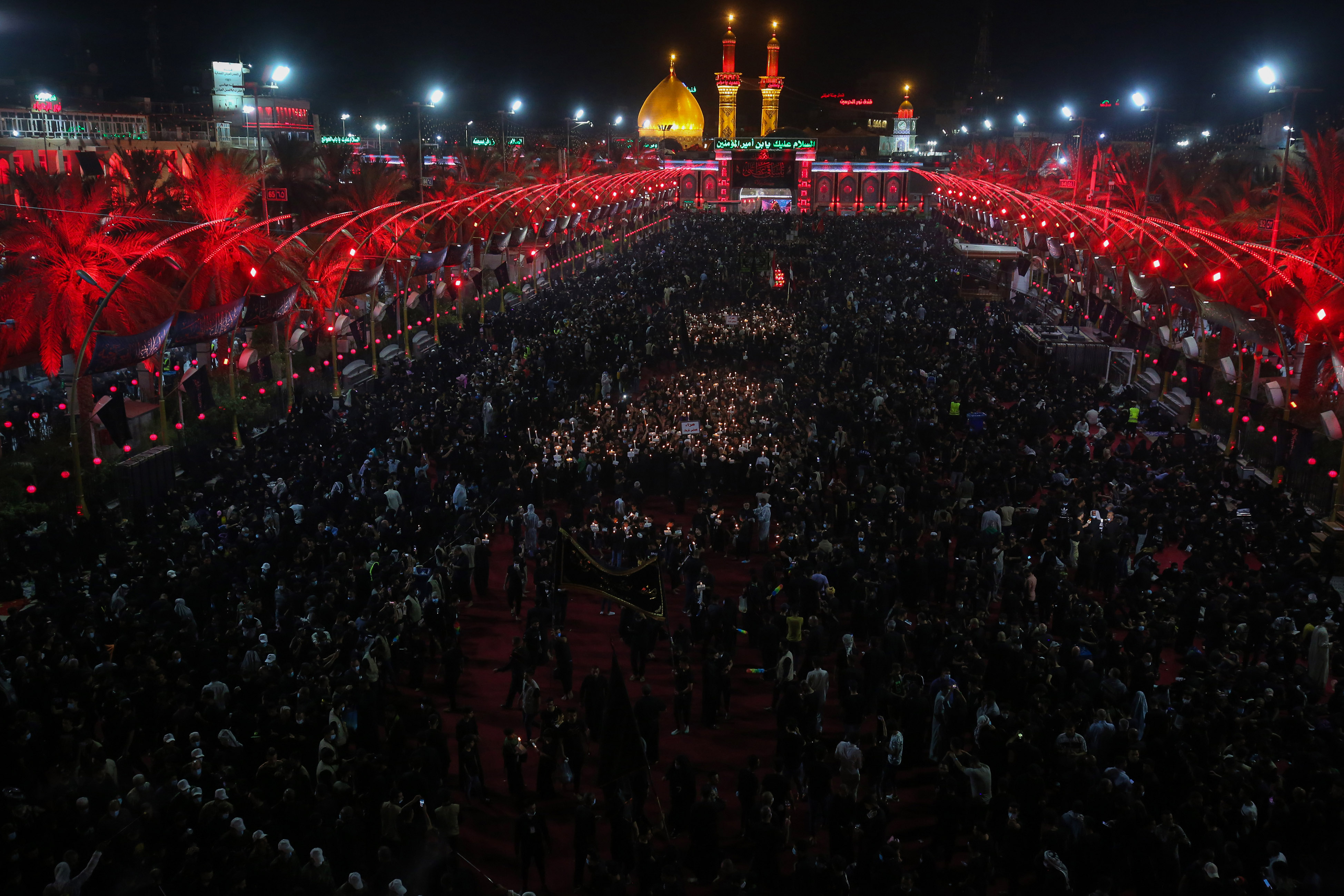 Shia Muslim worshippers, wearing protective face masks, attend a mourning ritual to commemorate martyrdom of Prophet Mohammad's grandson Imam Hussein during the Islamic month of Muharram outside the shrine of the Imam al-Abbas (Hussein's half-brother) in Iraq's central holy shrine city of Karbala. August 29, 2020. (Photo: Ahmad al-Rubaye/AFP)